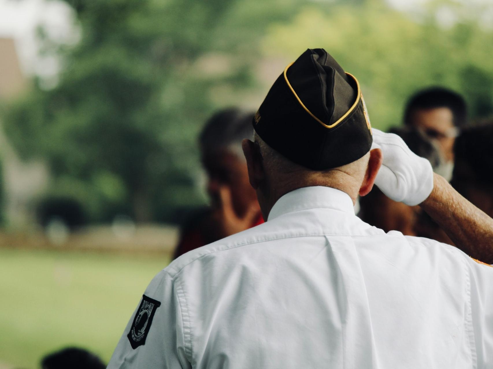 man wearing white uniform saluting